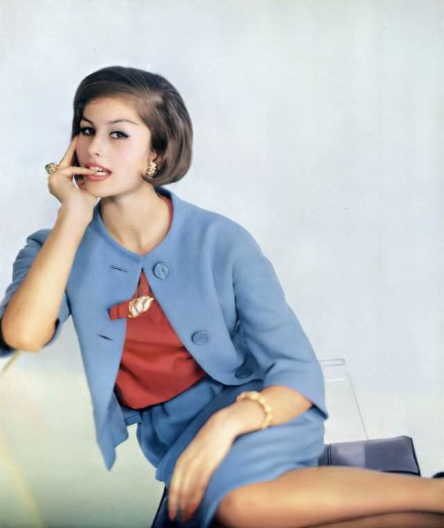 Tamara Nyman in sky-blue wool tweed suit with geranium-pink silk blouse by Mollie Parnis, jewelry by David Webb, January 1, 1961