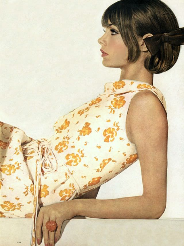 Jean Shrimpton in white linen dress printed with spice-yellow pansies, with turtleneck and string tie at the waist by Mollie Parnis, KJL ring, June 1, 1964