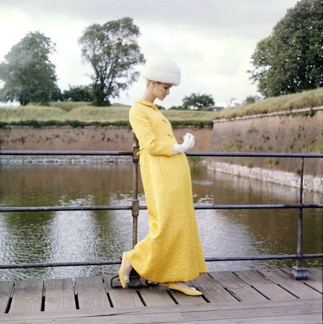 Model in an evening coat of yellow matelasse by Mollie Parnis, Denmark, Vogue, October 1, 1964