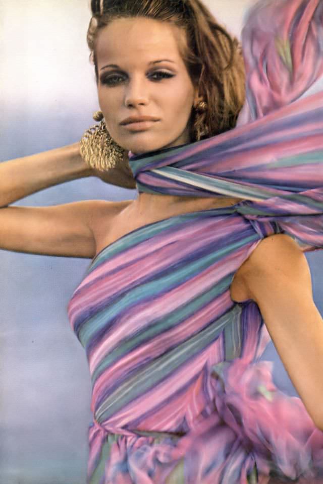 Veruschka in beautiful colorful silk chiffon dress that scarfs one shoulder and swirls the body in a silken swirl, by Mollie Parnis, Vogue, April 1, 1965