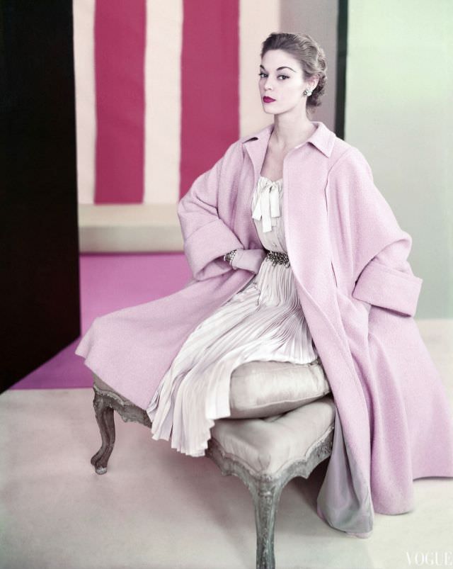 Jean Patchett wearing pale pink poodle coat by Swansdown over dress of pleated silk Shantung by Mollie Parnis, jewelry by Miriam Haskell, 1952
