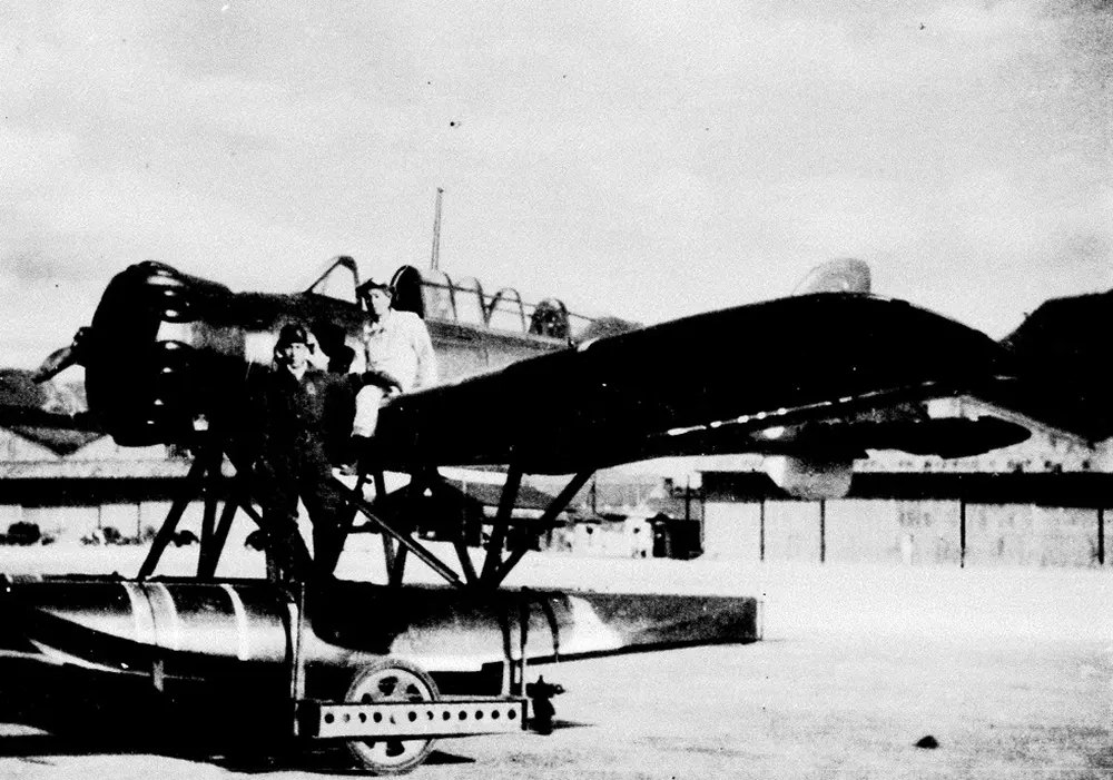 Nobuo Fujita standing by his Yokosuka E14Y “Glen” seaplane.