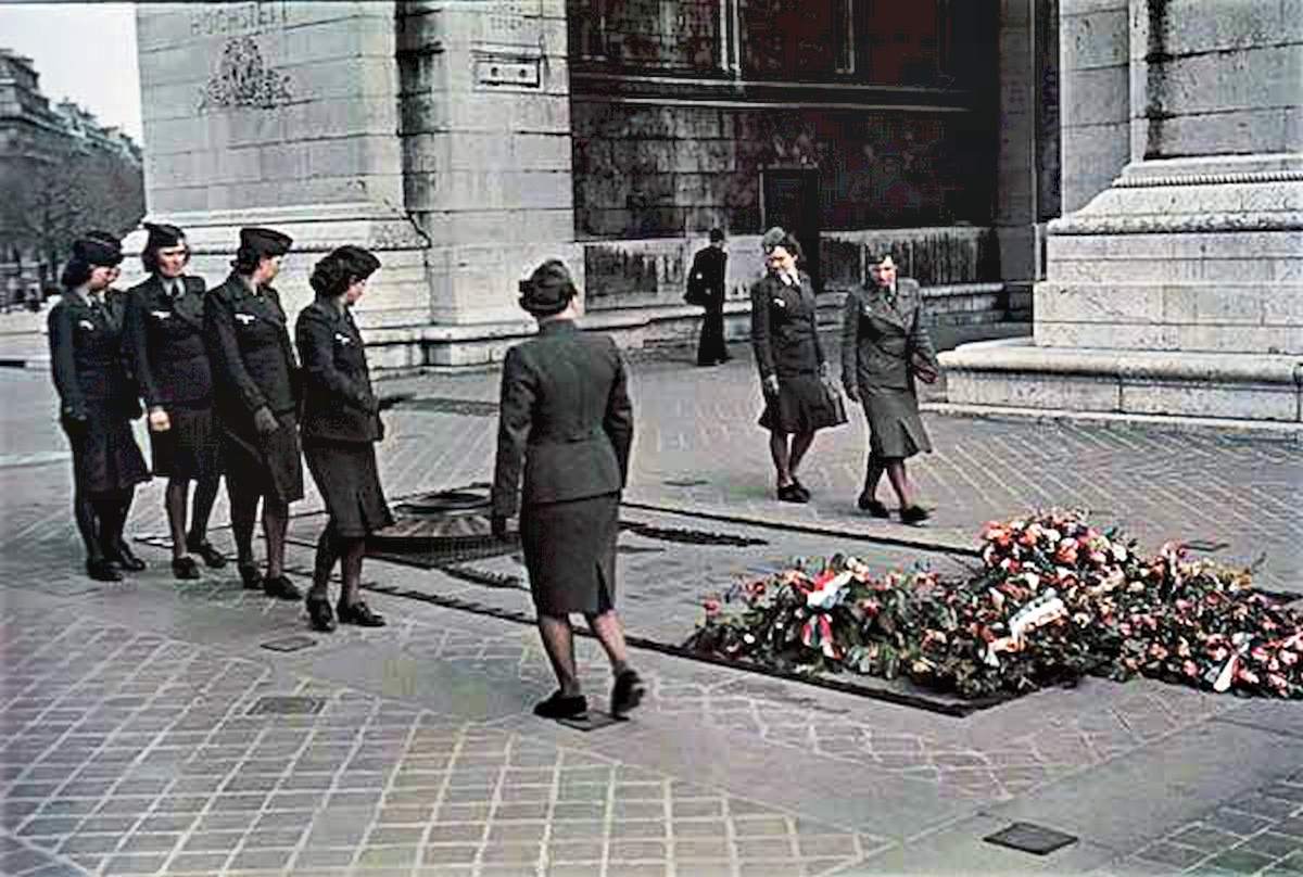 Women in military uniforms look at a war memorial commemorating those killed in the First World War just over two decades earlier.