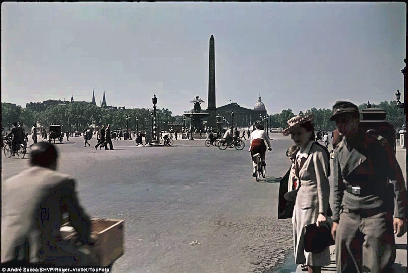 A soldier and civilians mill around near Cleopatra’s Needle in the Place de la Concorde, one of three obelisks taken from Egypt and re-erected in Paris, London, and New York during the 19th Century.
