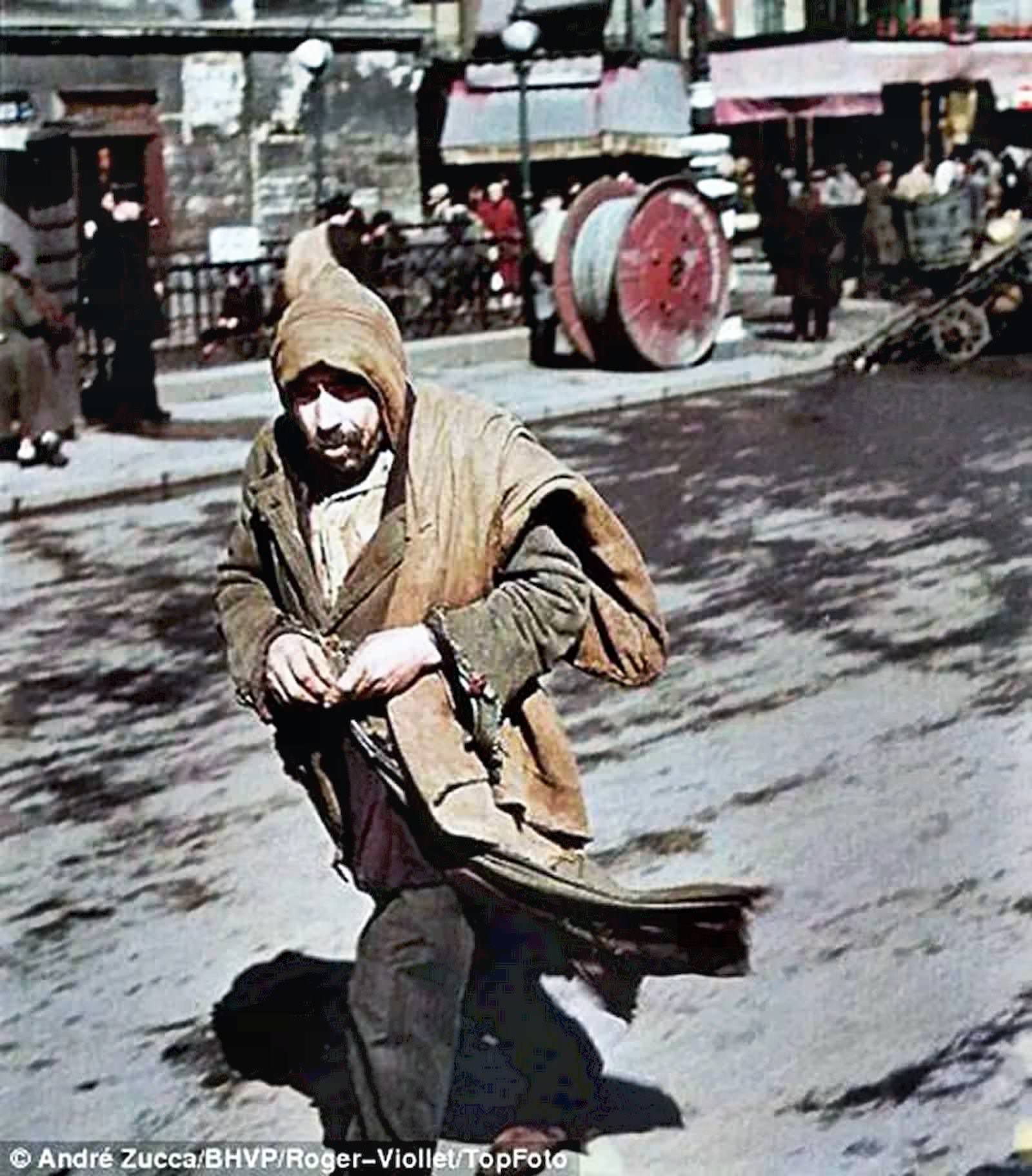 A man dressed in dirty clothes hurries along the road.