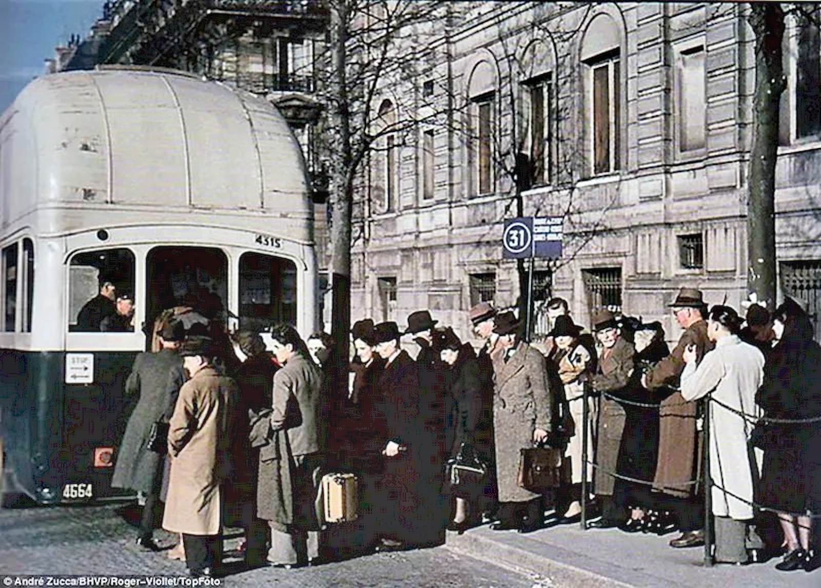 Parisian commuters queue to board a bus on a chilly early morning.