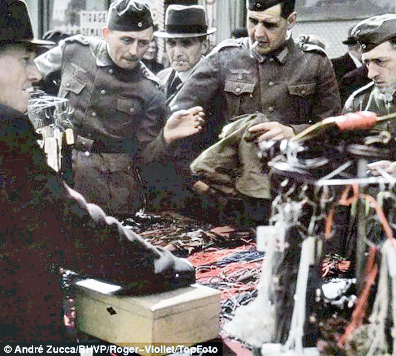 Nazi soldiers are shown participating in Paris life and are seen shopping at the market.