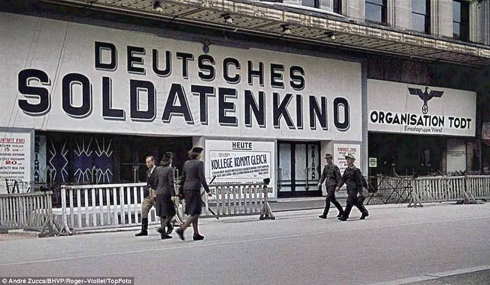 A theatre, which has an Imperial Eagle painted on its wall, proclaims itself as a German soldier’s cinema (Deutsches Soldatenkino).