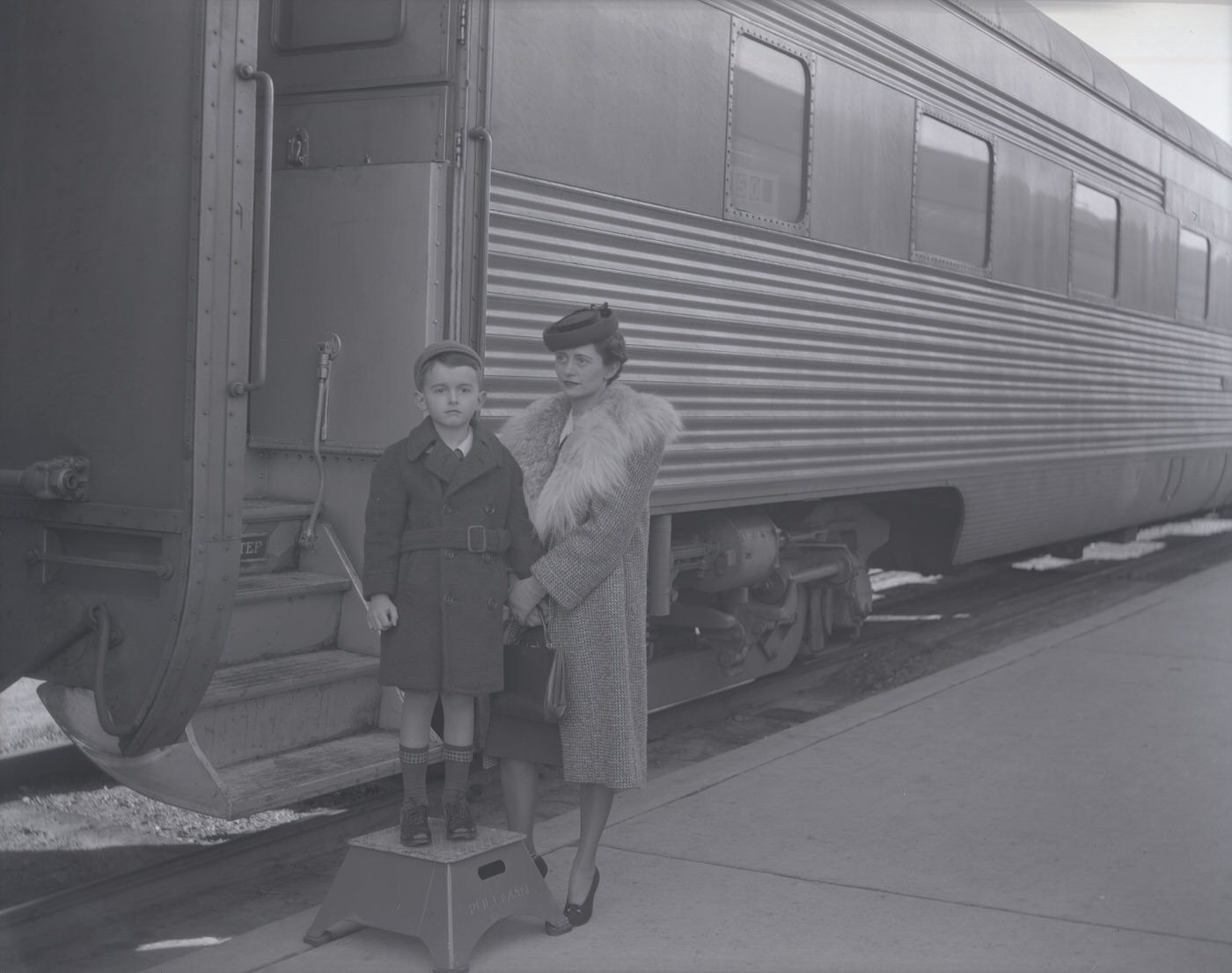 Woman and Young Boy Standing Next to a Santa Fe Train, 1941