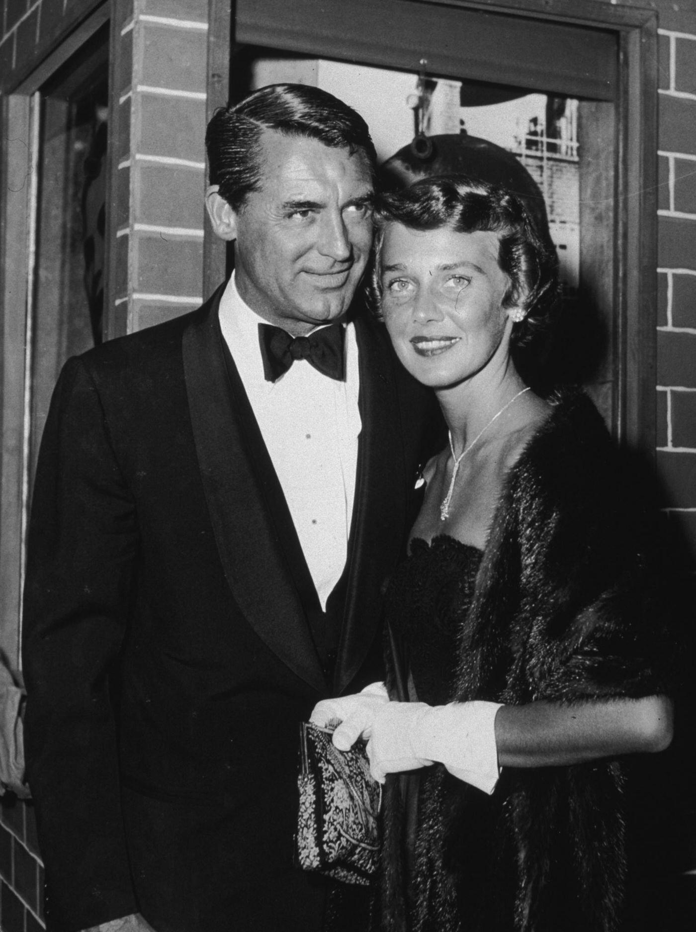 Cary Grant and his third wife, Betsy Drake, pose outside a theater while attending the premiere of 'Rear Window,'