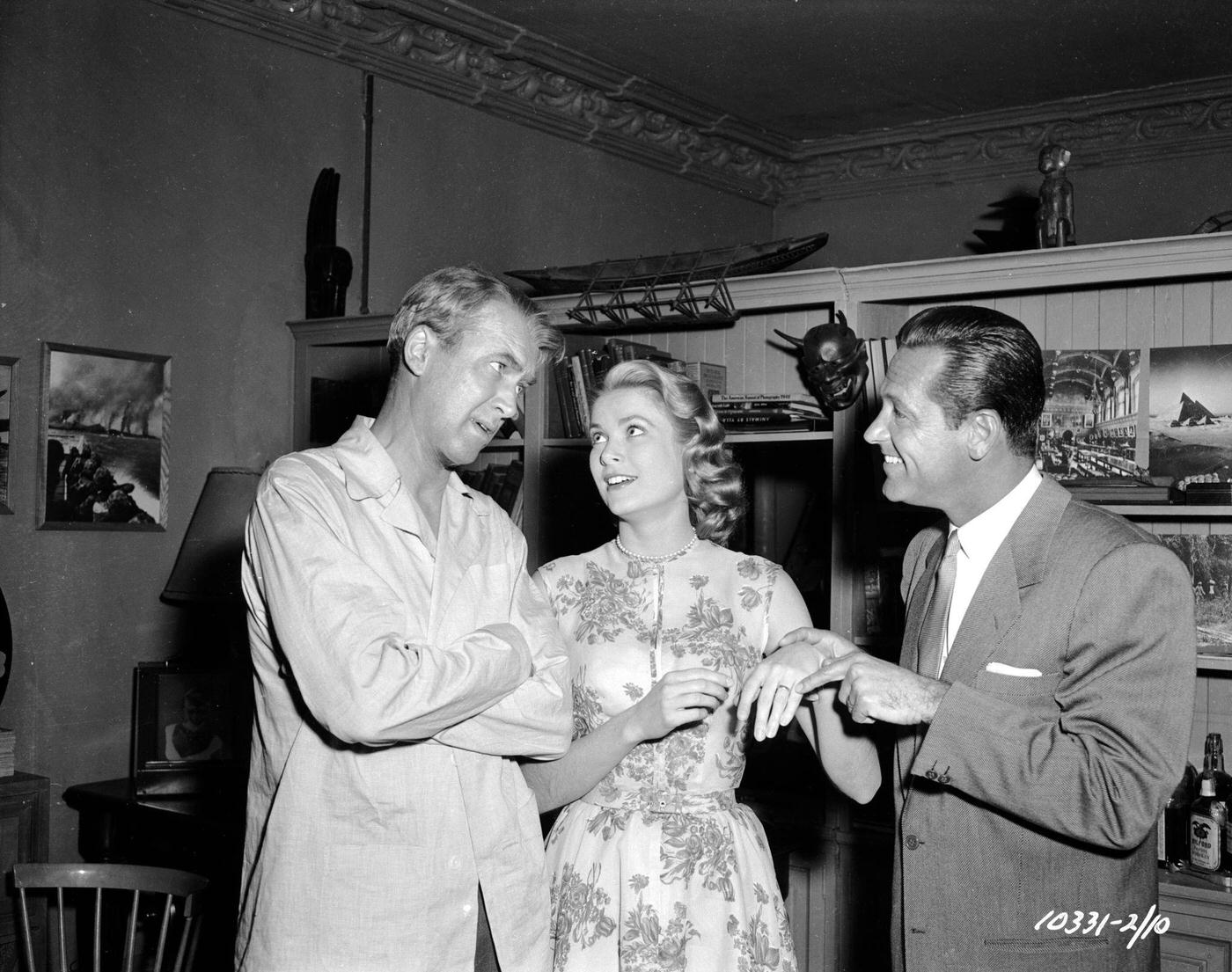 William Holden points out Grace Kelly's engagement ring to James Stewart in a moment of fun on the set of Hitchcock's 'Rear Window'.