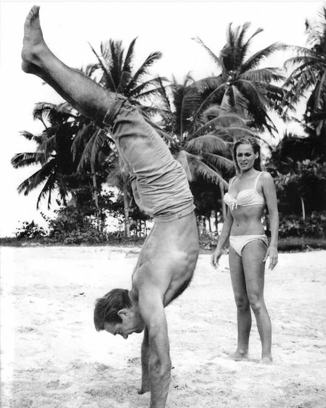 A Hands-On Lesson: Sean Connery Helps Ursula Andress Perfect a Handstand