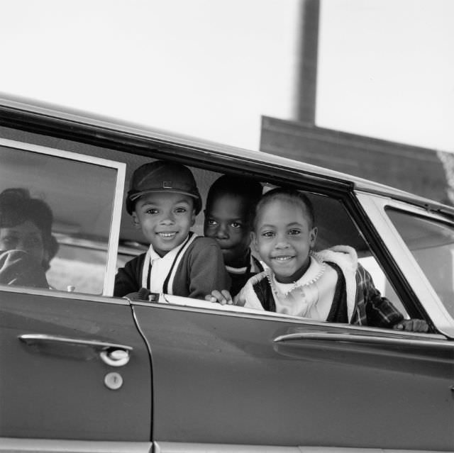 Michael Willis, Harry Williams and Dwania Kyles sit in the back of a car during the first day of Memphis school integration, 1961.