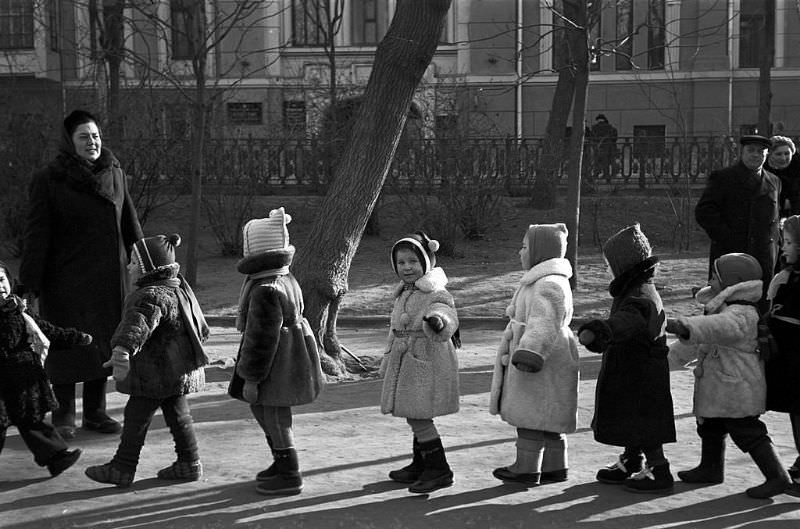 Warmly-dressed children in a public garden.