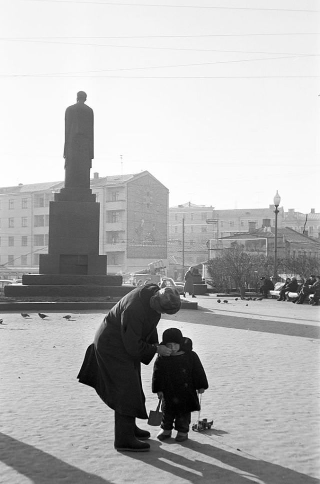 A man wiping a child's face on Pushkin Square.