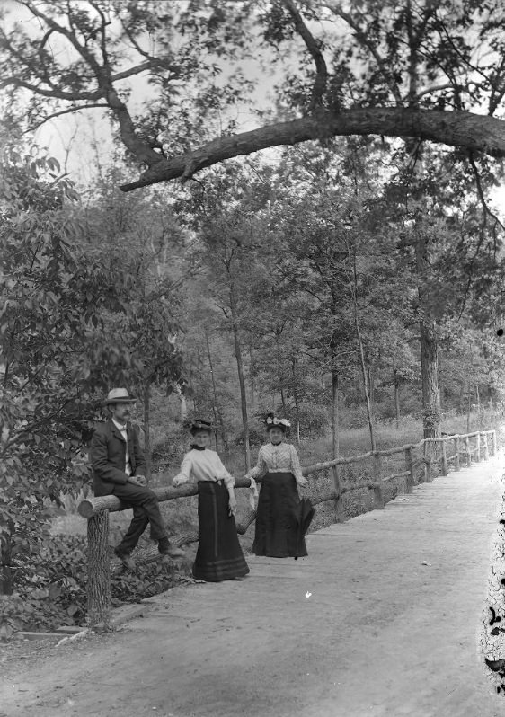Three People Leaning on a Wooden Railing, 1900