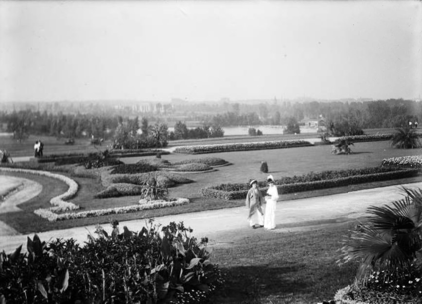 Nellie Hanlon and Adele Dubach, with flowers, near birdcage, Forest Park, 1914