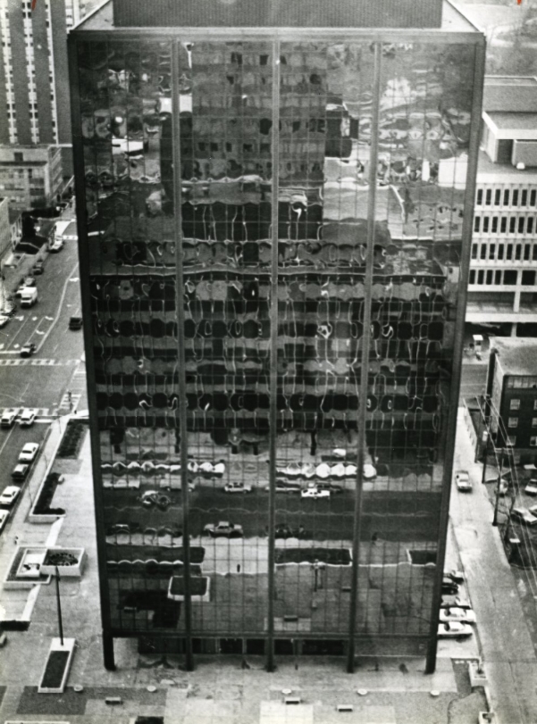Downtown life is reflected in the shimmering panels of the Chromalloy Building, 1980