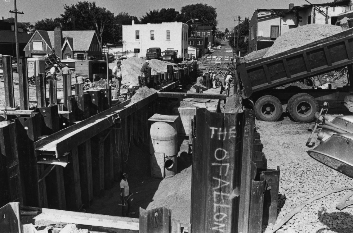 Construction crews work to fill what was a gaping hole at South Broadway and Fillmore Street, 1982