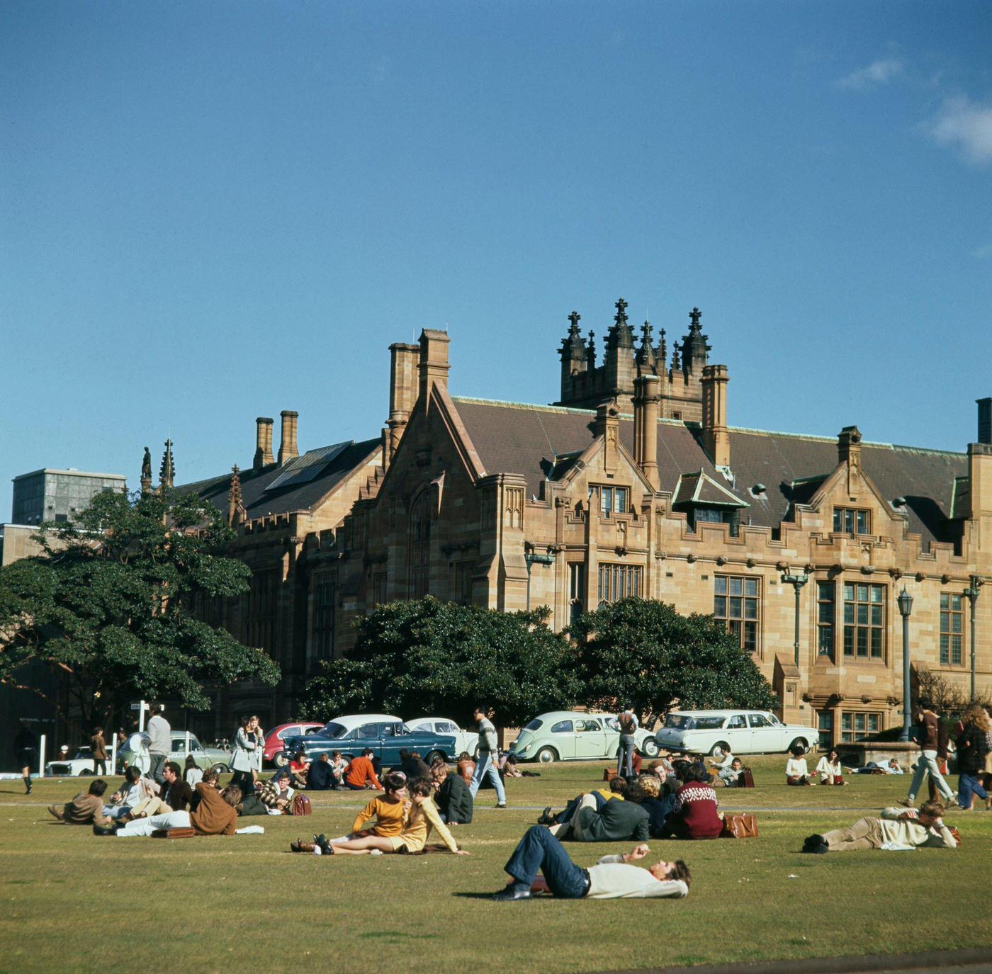 Students relax on grass lawns in front of the Main Campus Building of the University of Sydney in the Camperdown district of Sydney in New South Wales, 1965