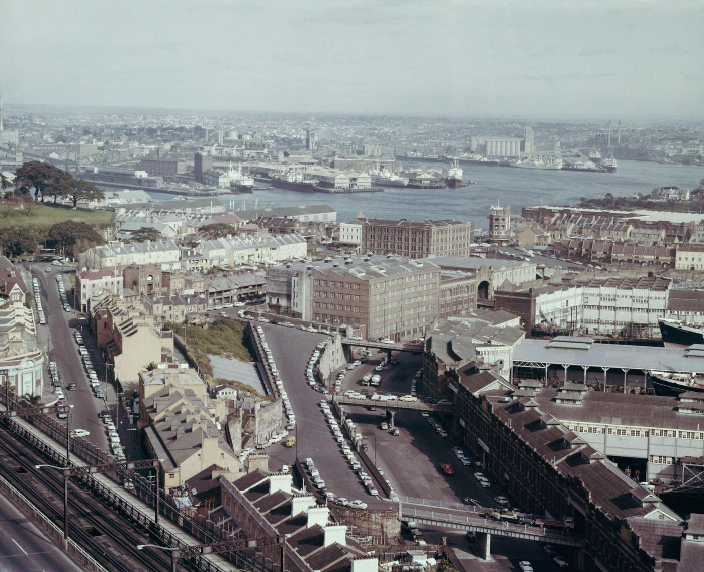 View from the top of Sydney Harbour Bridge of ships moored at wharves alongside Hickson Road and Walsh Bay in the Dawes Point district of the city of Sydney, 1963