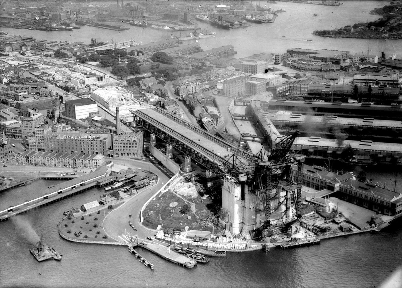 Aerial view of the construction of the Sydney Harbor Bridge and its approaches.