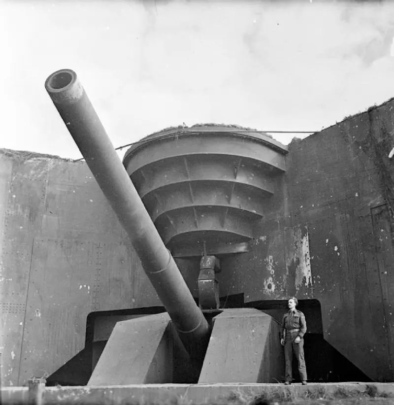 A British soldier poses next to the recently captured German 380 mm gun Todt Battery at Cap Gris Nez.
