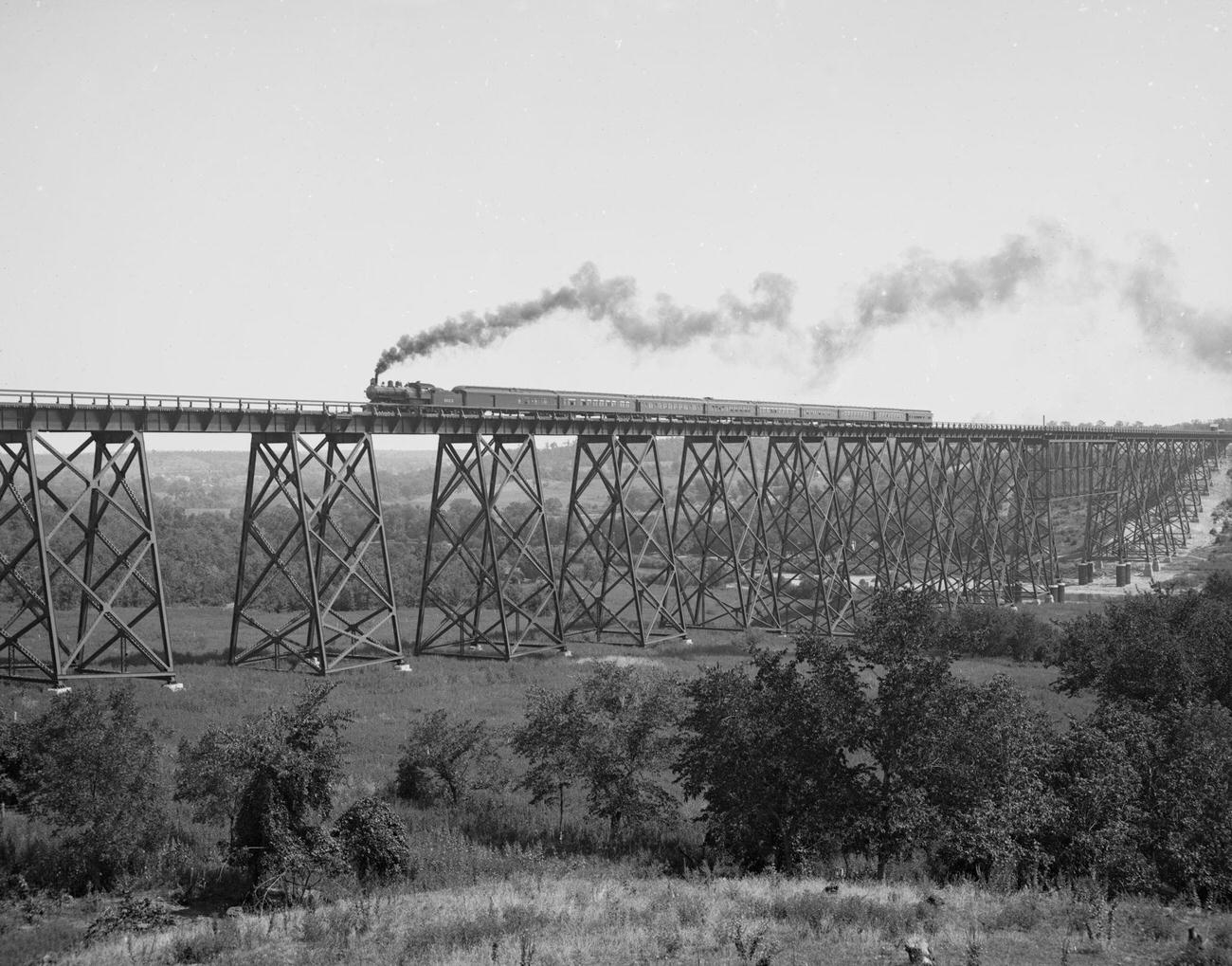 Steam locomotive & Train passes over Valley Trestle Bridge -Chicago & North Western Railway viaduct over Des Moines River, near Boone, Iowa