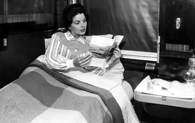 A woman reading in a Blue Train compartment at night