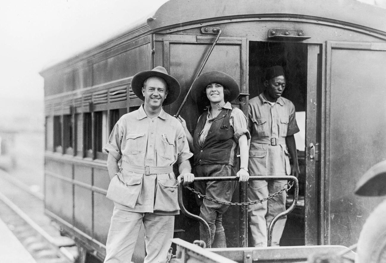 American anthropologists Martin and Osa Johnsonith their houseman at the back of train on the Kenya and Uganda Railroad, Nairobi, Kenya.