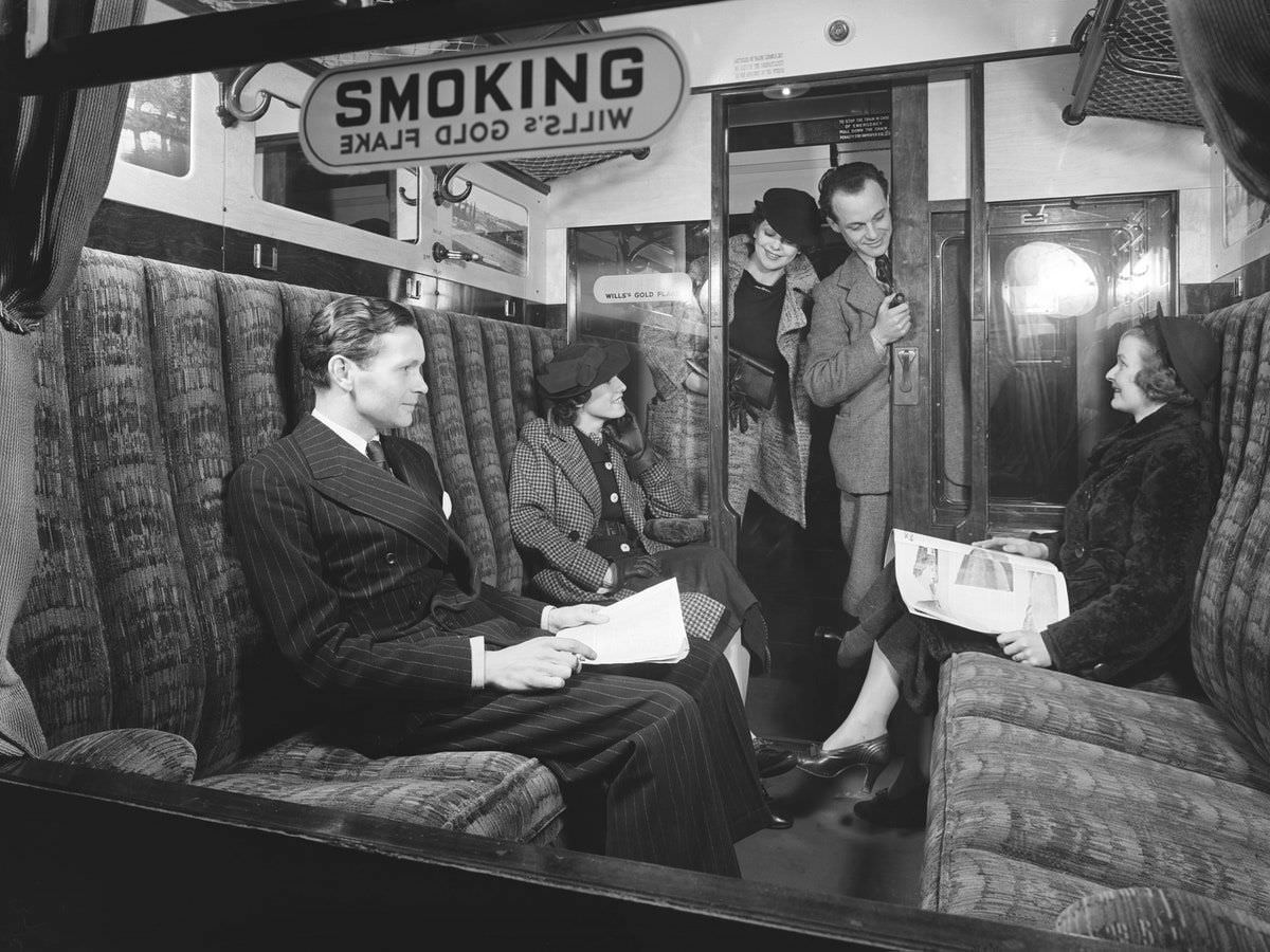 Passengers in a first-class railway carriage smoking compartment, 1936.