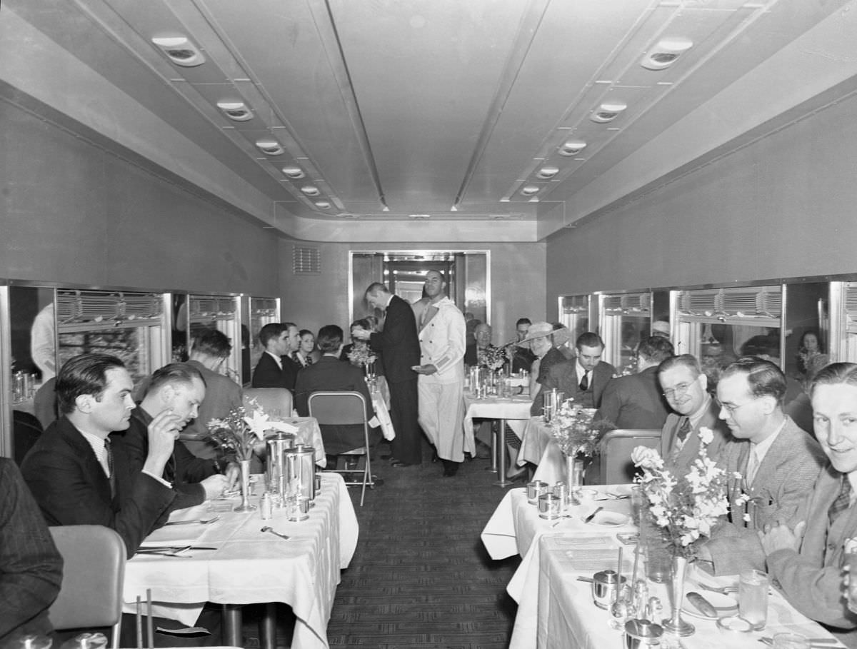 The luxurious and spacious dining of the new, streamlines Twentieth Century Limited, crack New York Central Railroad flyer showing the passengers at their meals during the “preview” run to New York City, 1938. The new train, first all-room train in America, will go into service between New York City and Chicago June 15th, on a 16-hour schedule.