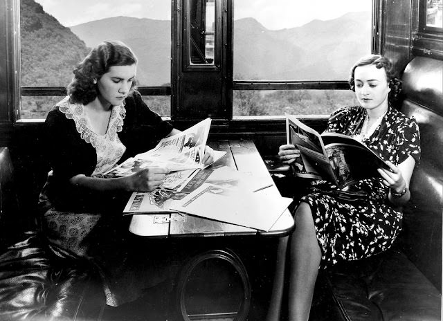 Two girls reading magazines in a First Class compartment, 1940s
