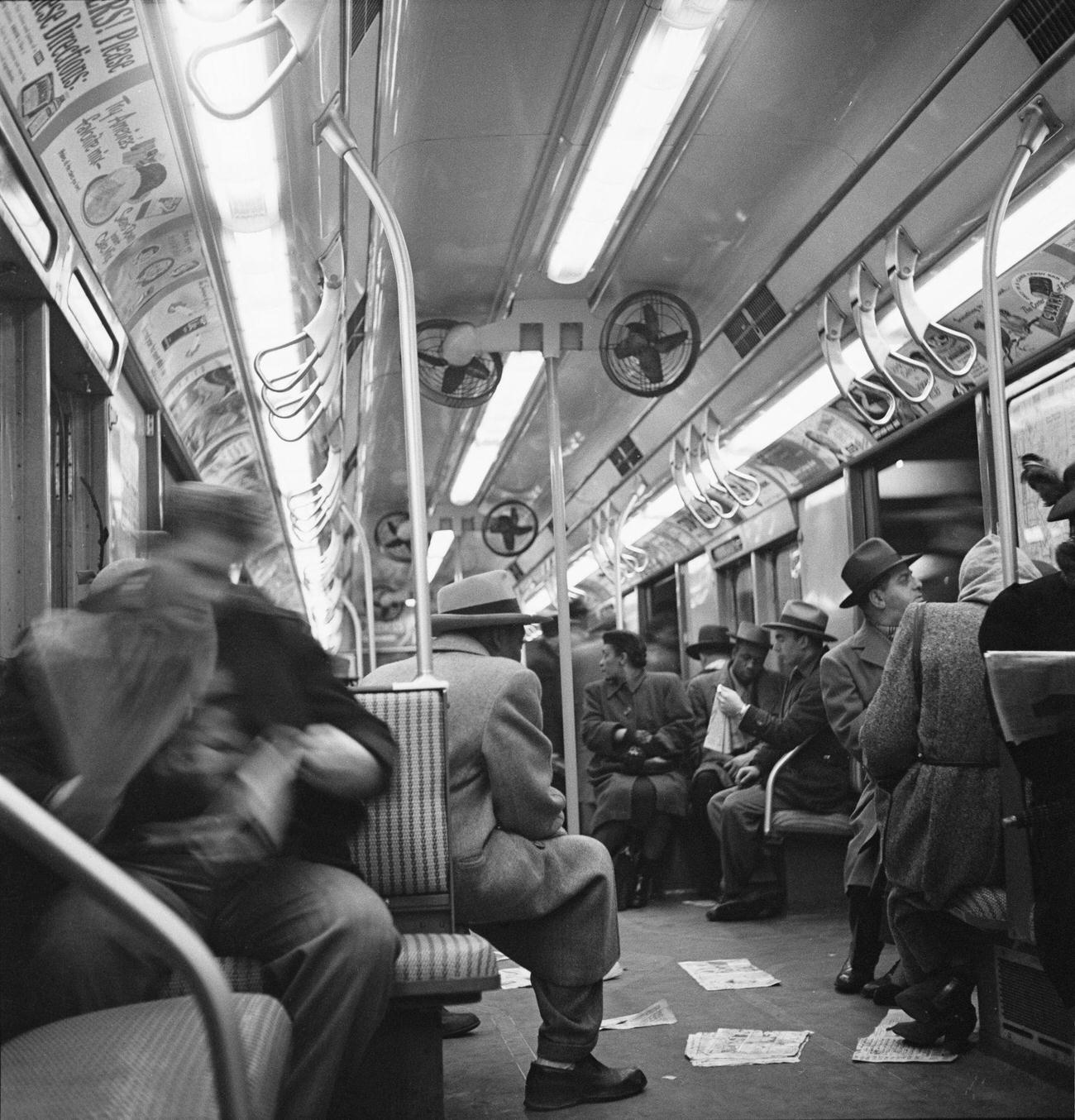 Passengers on a train, with air-conditioning fans fixed to ceiling-mounted brackets, at Times Square New York City Subway Station, Times Square in the Manhattan borough of New York City, 1948