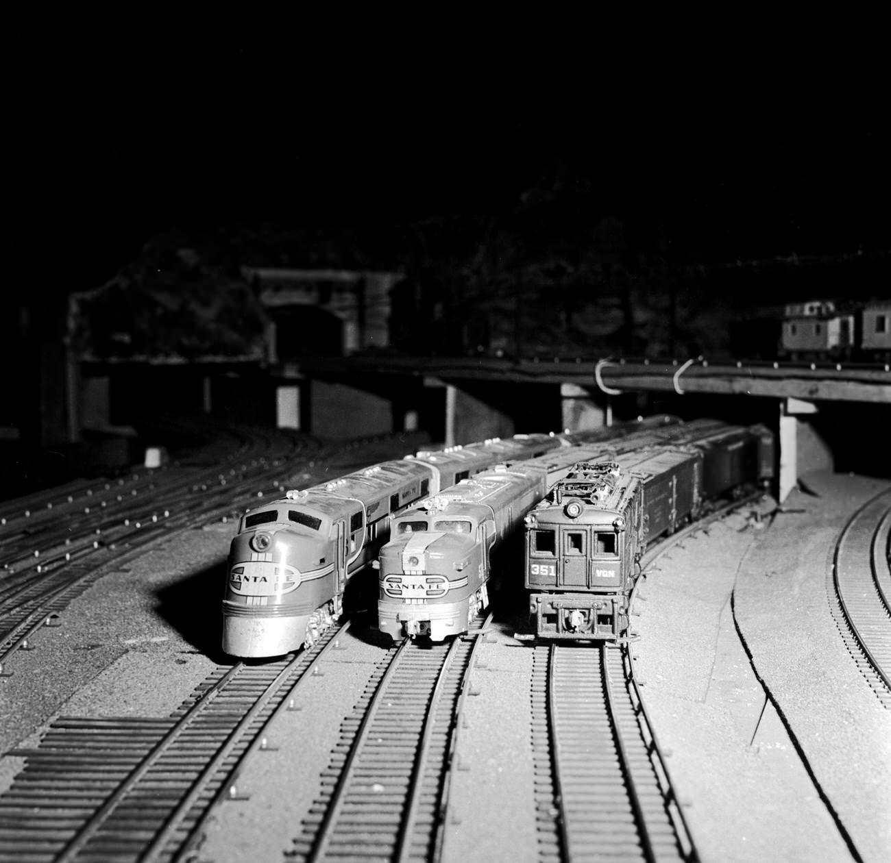 Three realistic miniature trains owned by members of the New York Society Of Model Engineers line up on the track.