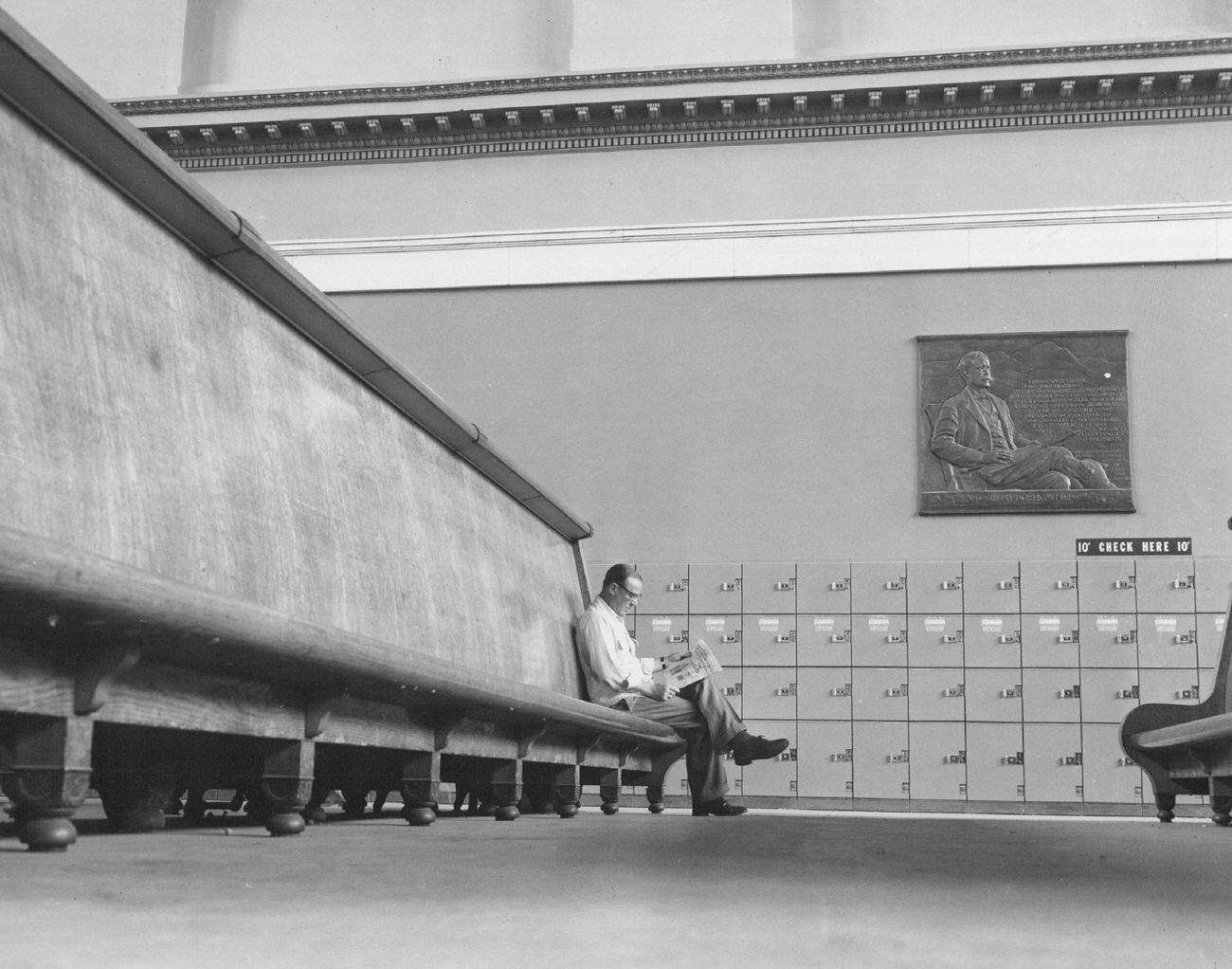 A lone traveler sitting in almost empty waiting room at Denver's union station, 1953