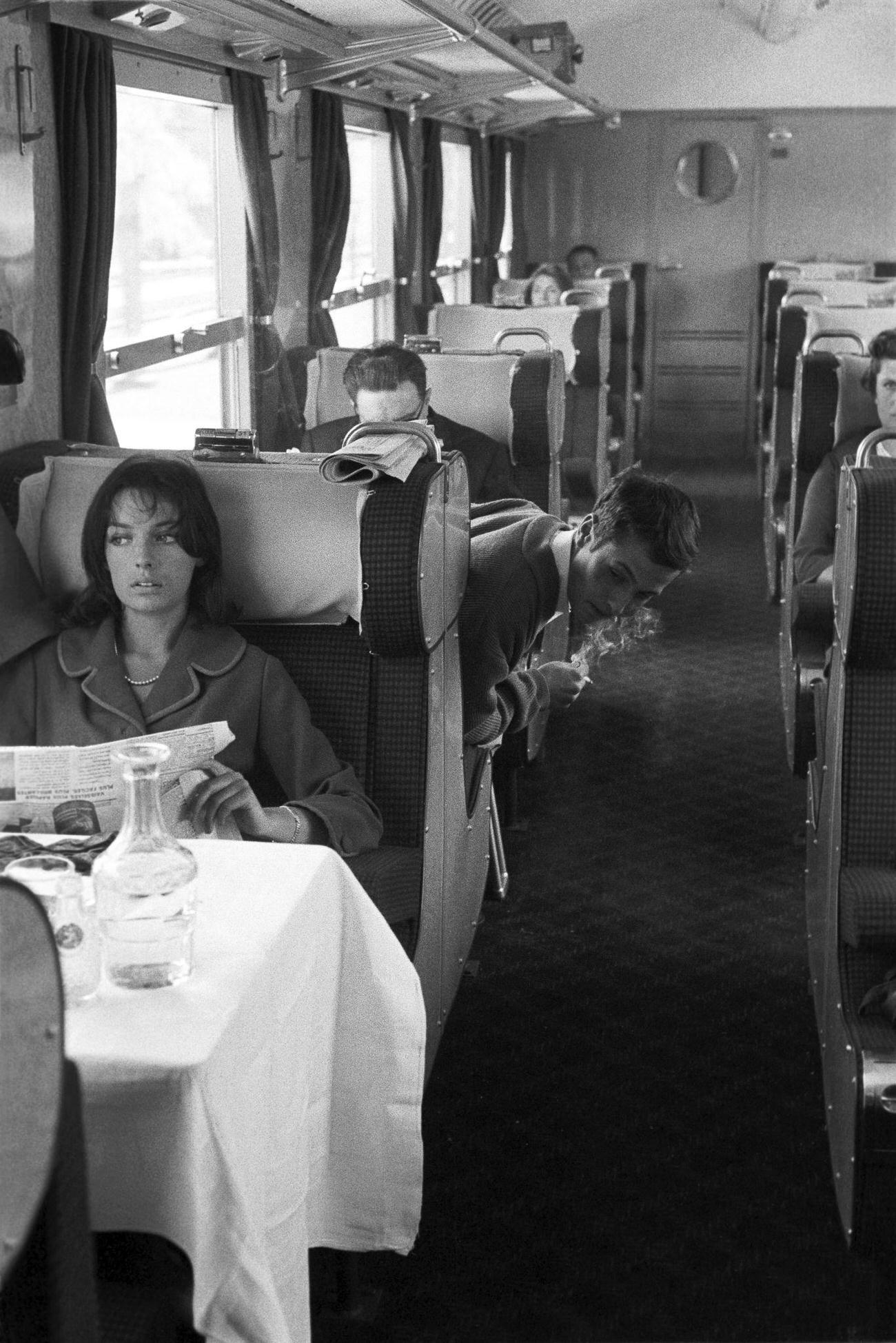 The actress Marie Laforet traveling by first class car on the Paris-Lille train, reading the newspaper on June 3, 1959.