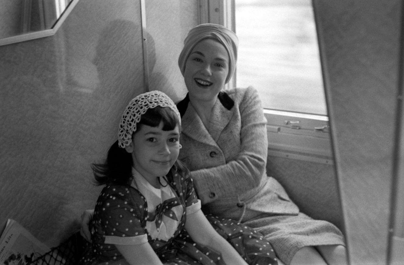 Edie Adams poses for a portrait with step-daughter Elizabeth (Bette) Kovacs while travelling on a train, 1956 outside of Padua, Italy.