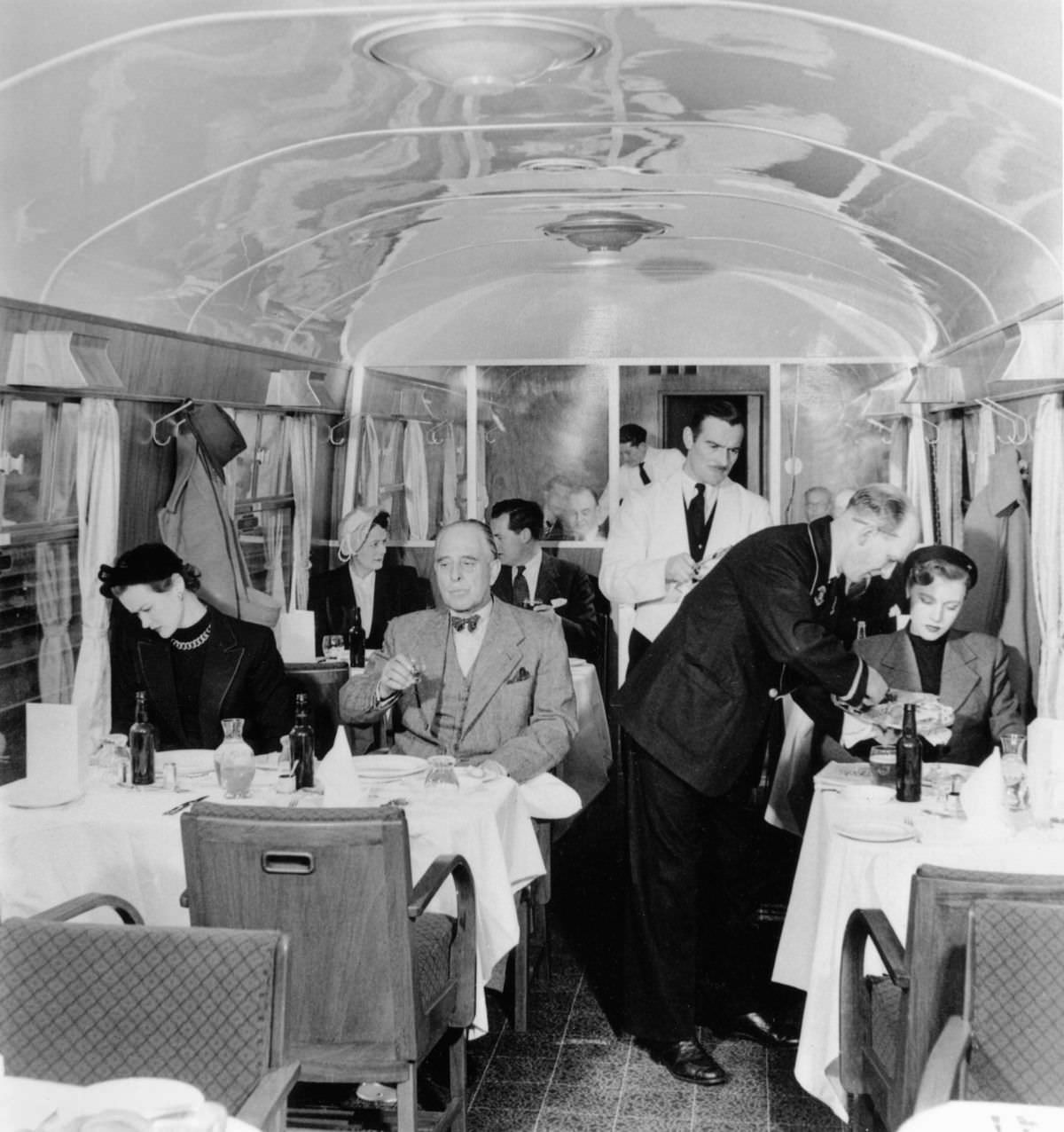 British Rail stewards serve drinks in a first-class dining car, 1951.