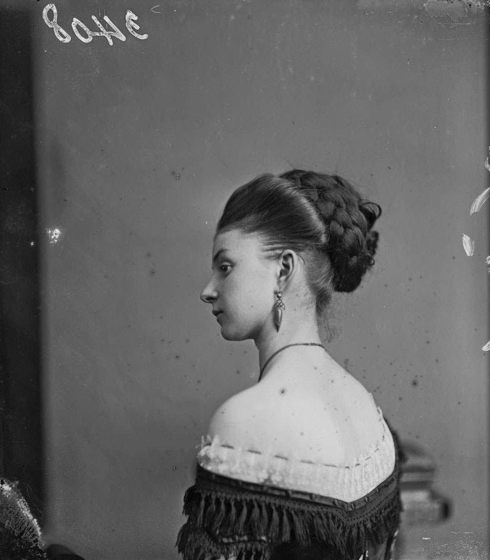 Miss Cornell posing in an off-the-shoulder gown and with an elaborate hairstyle, London, 1880.