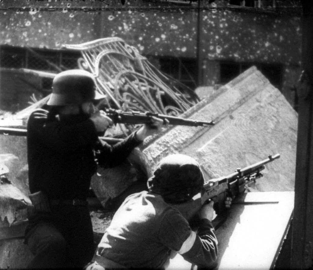 Polish partisans in shooting position behind a barricade.