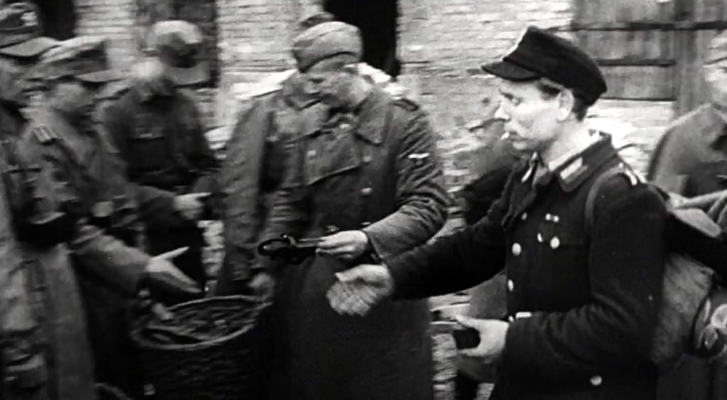 A Polish partisan surrendering his gun.