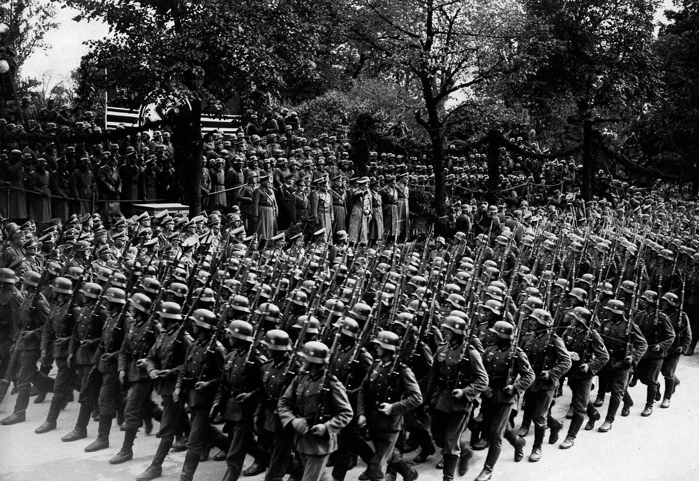 This photograph captures soldiers marching in front of Adolf Hitler on Ujazdowski Avenue in Warsaw during World War II in Poland.