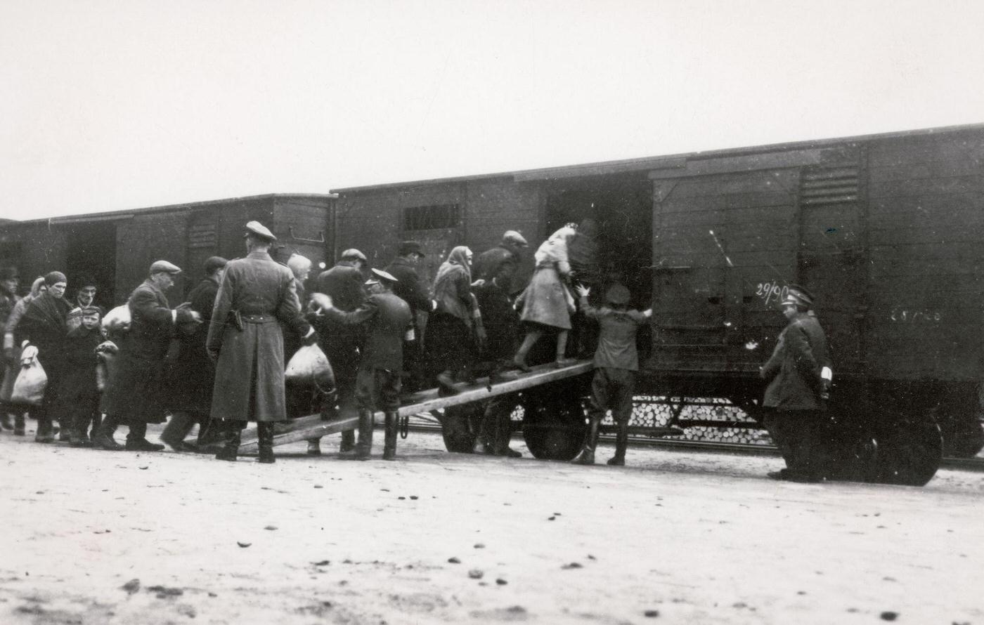 This photograph shows Polish Jews being deported in cattle carriages from a "reloading point" in Warsaw.