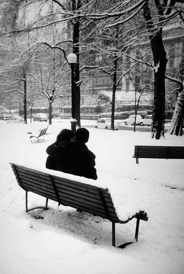 A couple sitting on a bench during the winter in Rome, 1960.