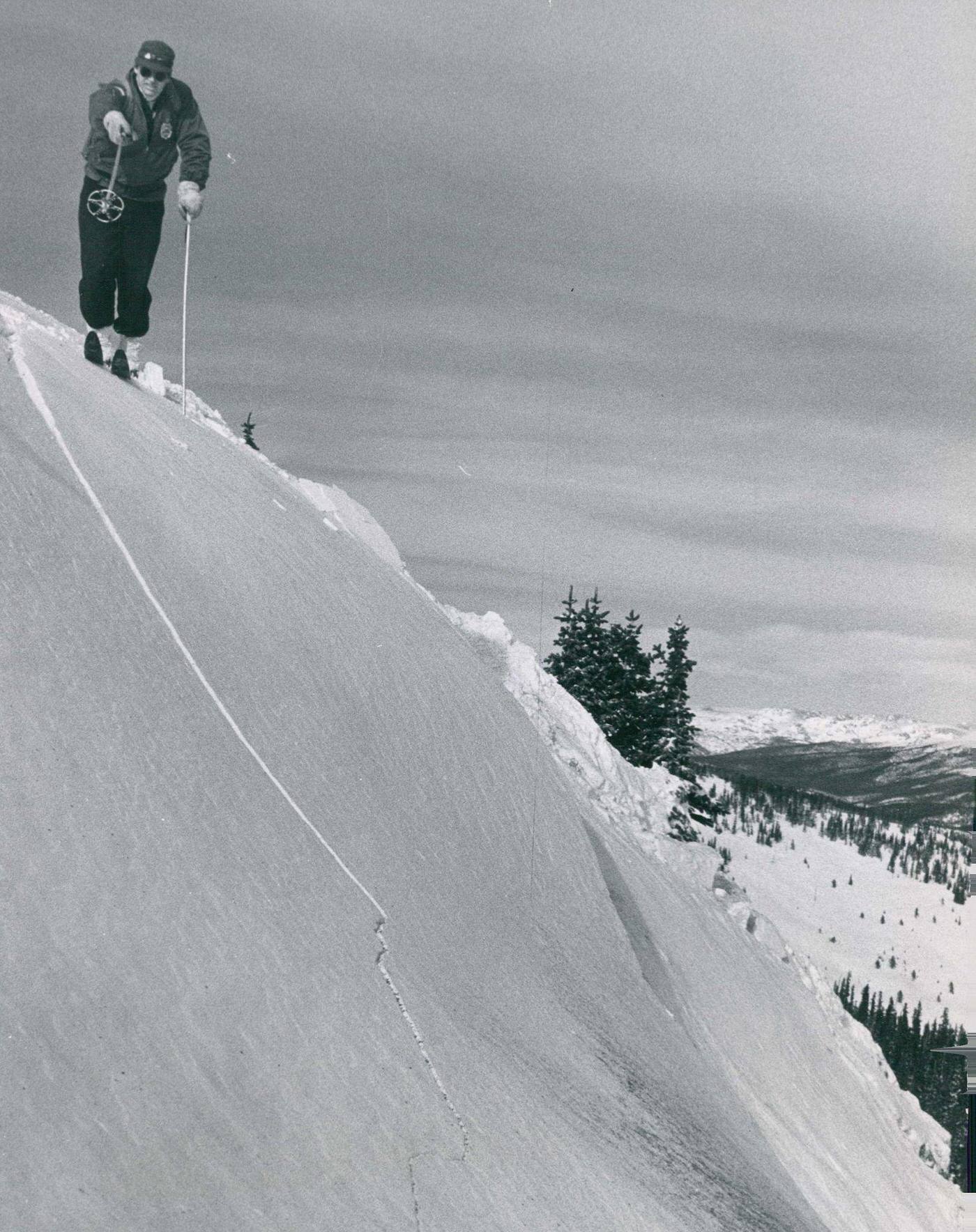 Dick Stillman, "avalanche buster" for the U.S. forest service atop Berthoud Pass, points out jagged fracture line in the snow.