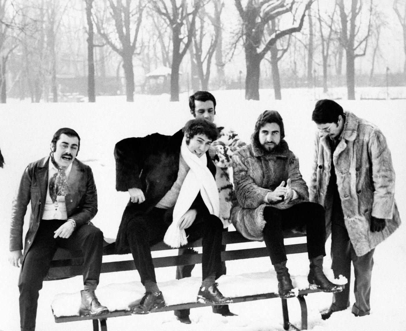 Italian band Dik Dik sitting on a snowy bench.