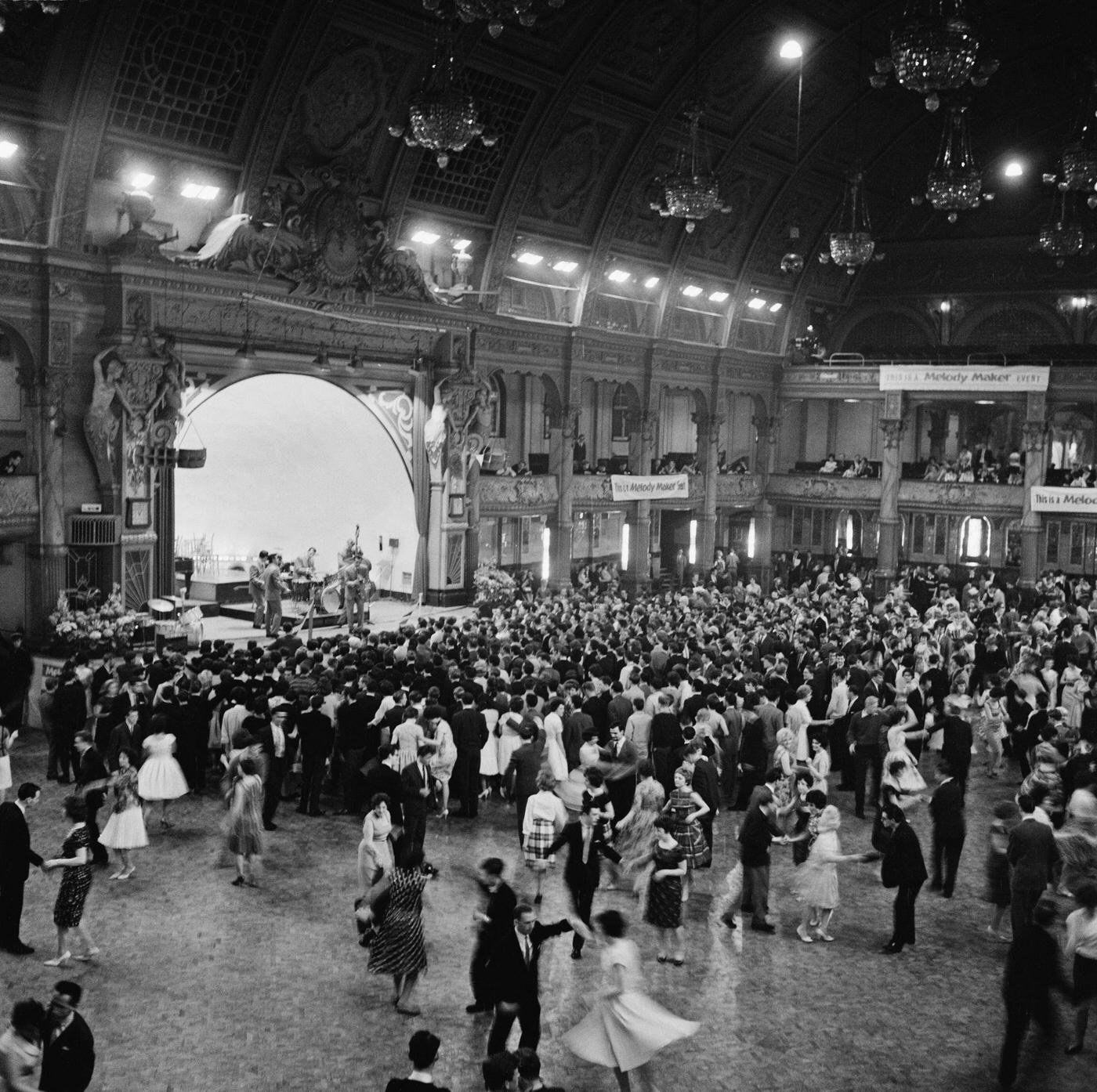 View of dancers and audience members on the dancefloor being entertained by a jazz band on stage at the Winter Gardens venue in Blackpool, Lancashire during the Melody Maker Festival in June 1961.