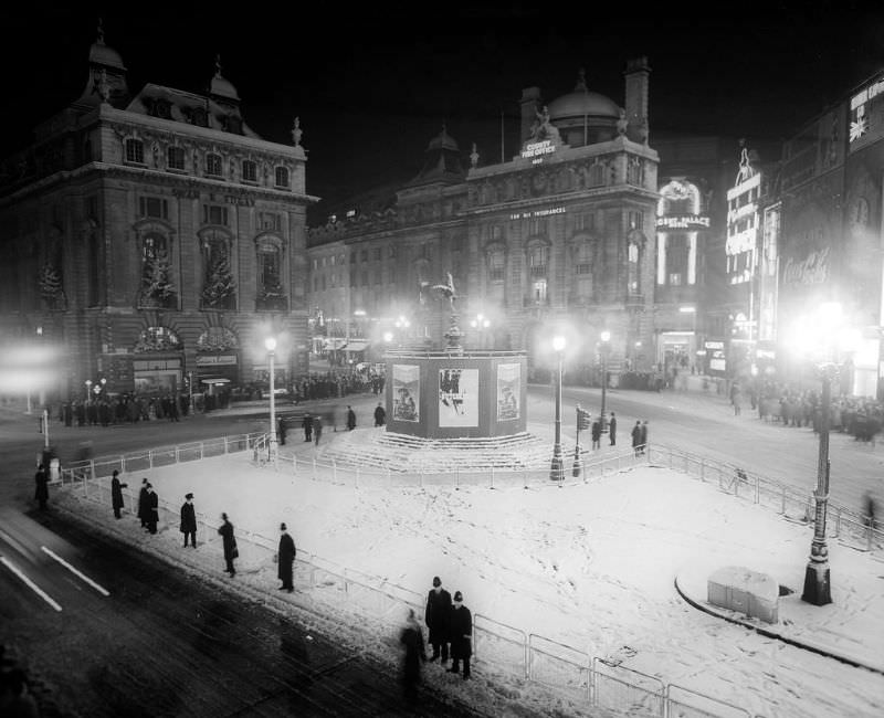 The statue of Eros in Piccadilly Circus, London on New Year's day, surrounded by policemen as midnight strikes, 1962. (Arthur Sidey)