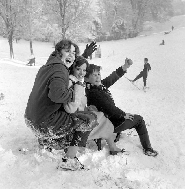 Children wave to the Mirror photographer before descending Hampstead Heath on New Year's Day, 1962.